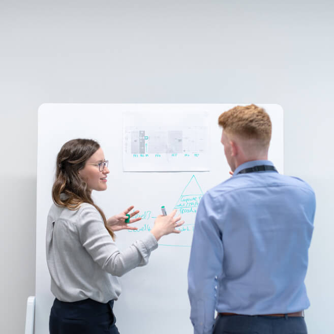 Two employees looking at a whiteboard